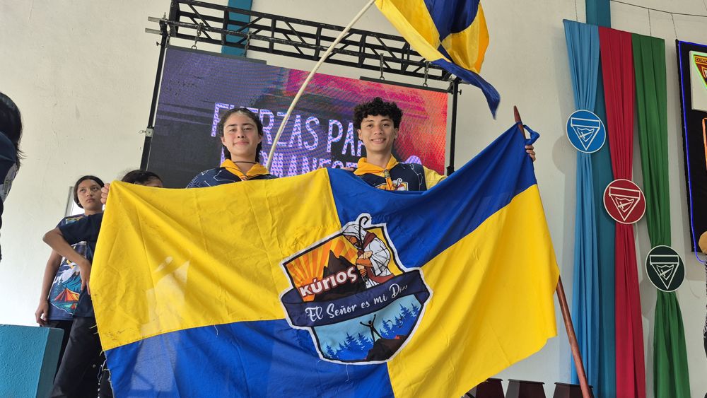 Jóvenes sosteniendo la bandera del Club Kúrios