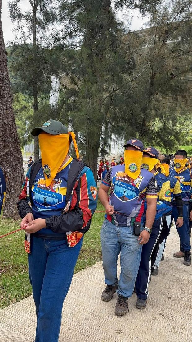 Jóvenes caminando con los ojos vendados guiados por su equipo