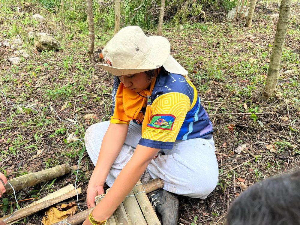 Joven haciendo amarres con bambú